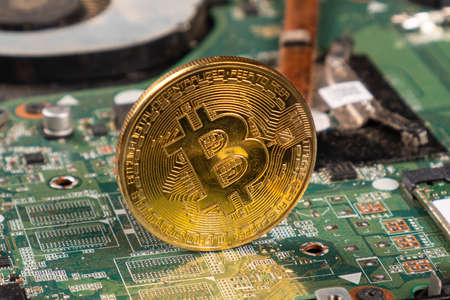 btc bitcoin gold coin on motherboard closeup