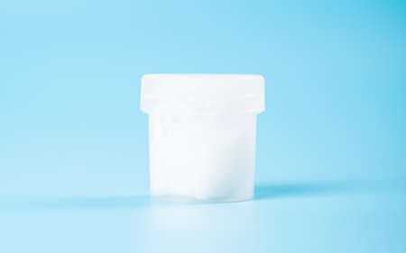 sperm donation concept, a test tube with a clear liquid on a blue background