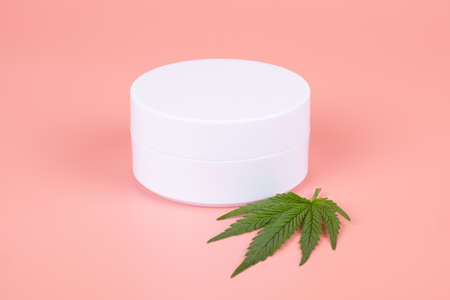cannabis cosmetics , natural marijuana cream and green leaf on beauty pink backgroundの写真素材
