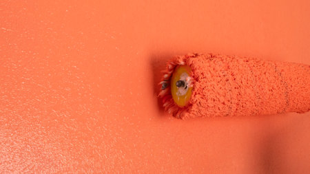 red construction roller paints the wall closeupの写真素材