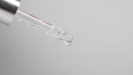 pipette with a drop essential oil on a gray background.の写真素材