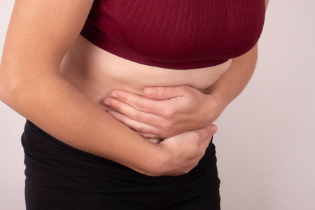 abdominal pain concept, woman hands holding her stomach.
