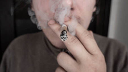 man with a cigarette in his mouth, harm of smoking, cigarette nicotine mist.の写真素材