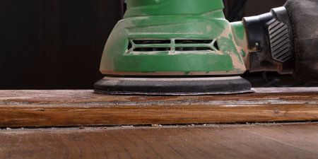 carpenter hand sanding a wooden door furniture with a grinder.の写真素材