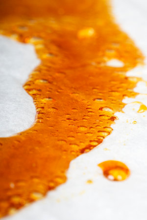 medical cannabis wax running down the paper, orange bubbles resin marijuana.の写真素材