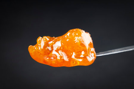 cannabis golden dab in dark, thc resin wax close up.の写真素材
