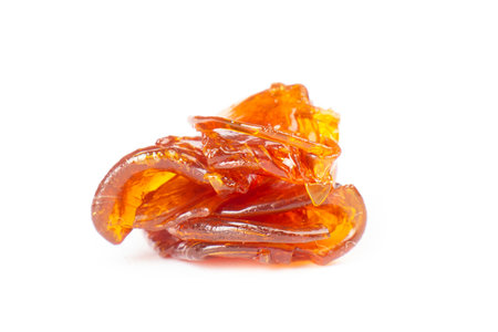 a piece of cannabis wax closeup isolate on white background. concentrate dab stone with high thcの写真素材
