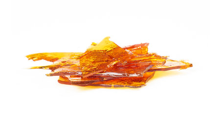 a piece of cannabis wax closeup isolate on white background. concentrate dab stone with high thc.の写真素材
