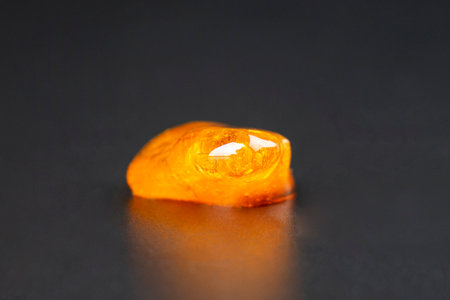 golden piece of marijuana wax on a dark background, cannabis resin closeup.の写真素材