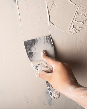 wall putty, spatula in hand closeupの写真素材