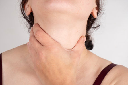 woman holding her throat, sore throat