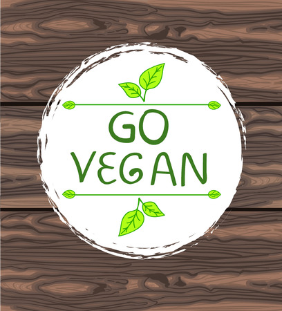 Go vegan handwritten text in circle hand drawn frame with vegnette and hand drawn leaves on brown background.のイラスト素材
