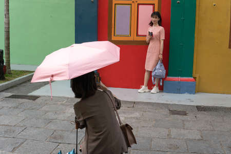 Singapore, Singapore - May 1, 2019 - Two unidentified women take photos in front on Tan Teng Niah...