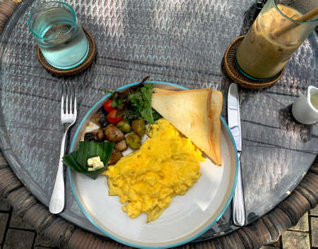 Western breakfast in outdoor restaurant setting in Ubud, Bali, Indonesia. Point of view colorful healthy breakfast.の写真素材