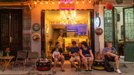 Hanoi, Vietnam - November 15,2019 : Group of tourist sitting at cafe waiting for train to pass, a...