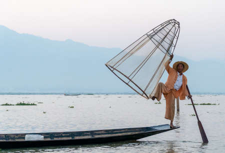 Nyaungshwe, Myanmar : March 12, 2020 - Fisherman pose for a picture Inle Lake. Once an old tradition fisherman now make money by posing for photos.のeditorial素材