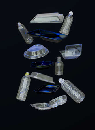 Falling clear water bottles on black background recyclables. Depicting motion of recycle plastic consumerism suspending and falling in mid-air isolated. Plastic containers and goods.の写真素材