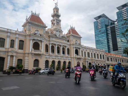 Ho Chi Minh, Vietnam - December 17,2019 : Covid people on scooters with facemask on in front of People's Committee of Ho Chi Minh City in District 1.のeditorial素材