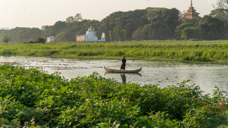 Mandalay, Myanmar - 3/8/2020 : Fisherman on boat near U Bein Bridge on lake with ducksのeditorial素材