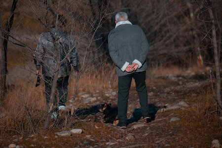 Senior man walking with dog in autumn forest. Retired people.の写真素材