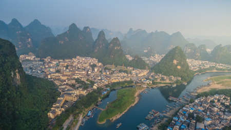 Breathtaking aerial view over beautiful karst mountain landscape and Li River covered with haze or...