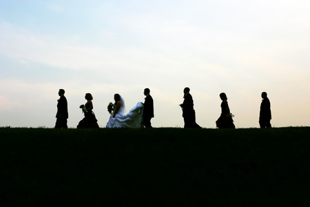 Silhouettes of a modern bridal party over a blue horizon.の写真素材