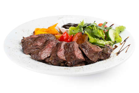 Beef fillet grilled with tomato, pepper, cucumber and herbs. Served with any sauceの写真素材
