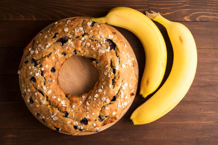 Banana cake with blueberries and cereal. Laid out on the Board with bananas on a wooden tableの写真素材