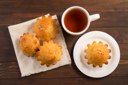 Sweet lush cupcake with tea. In white dish on wooden tableの写真素材