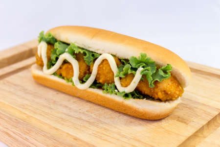 Hot dog serve on Chopping Wood with white background.の写真素材