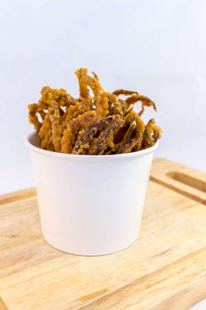 Fried squid serve in paper cups on Chopping Wood with white background.の写真素材