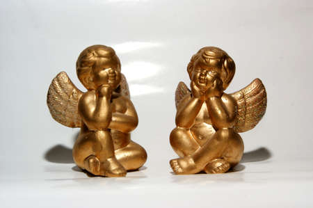 Two angels are relaxing on their clouds in the sky. 