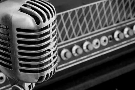 Vintage microphone standing near a rare vacuum tube amplifier, Black and Whiteの写真素材