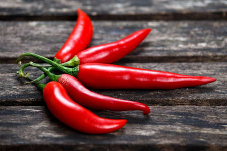 Organic Red Chili Hot Peppers on old wooden table. background.
