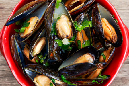 Mussels in garlic butter sauce in Red bowl.の写真素材
