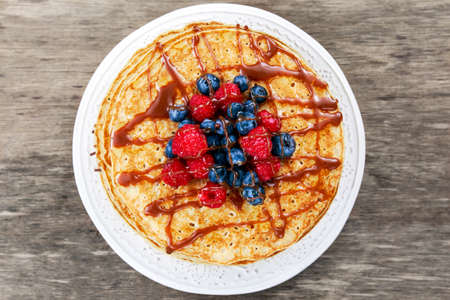 Fresh golden pancakes with raspberries, blueberries. on plateの写真素材