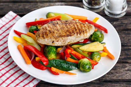 Grilled chicken fillet, breast with cooked vegetable  on platesの写真素材