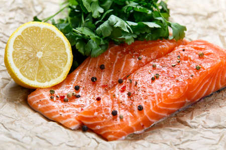 Raw Salmon fish fillet with fresh herbs on crumpled paperの写真素材