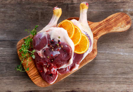 Free range Duck legs with oranges and herbs. on old wooden tableの写真素材