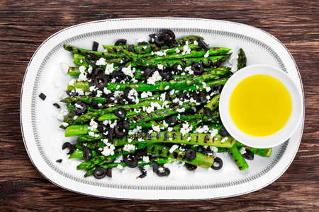 Grilled asparagus salad with feta cheese, olives and souce.の写真素材