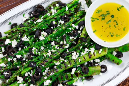 Grilled asparagus salad with feta cheese, olives and souce.の写真素材