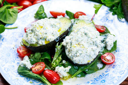 Avocado halves stuffed with cottage cheese and vegetables.の写真素材