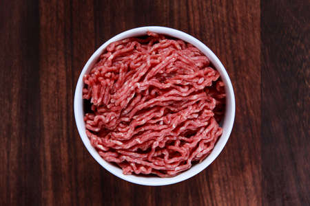 Fresh raw minced beef on wooden table.の写真素材