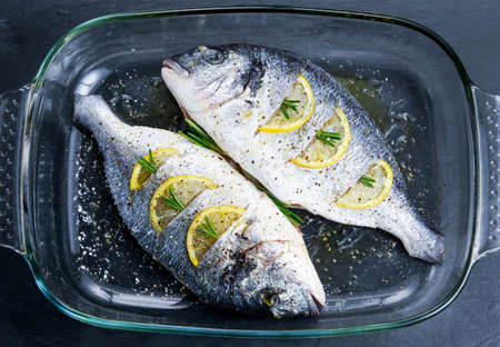 Fresh Raw Sea Bream Fish with herbs. ready to cook in oven. background