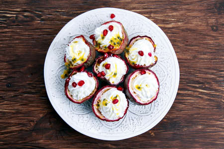 Passion fruit and whipped cream dessert with pomegranate seeds.の写真素材