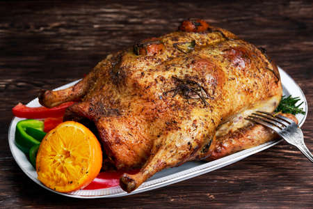 Roast Duck and oranges on a black wooden tableの写真素材