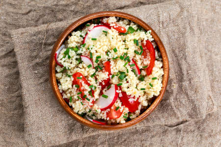 Homemade Fresh Couscous salad with vegetables wooden bowl. backgroundの写真素材