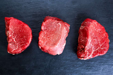 Fresh Raw Beef steak Mignon on blue dark board background. ready to cookの写真素材