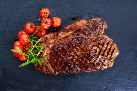 Grilled Beef Sirloin Steak on blue stone background, with vegetablesの写真素材
