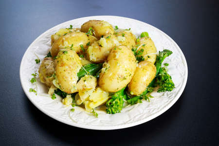 Young boiled potatoes with butter and vegetablesの写真素材